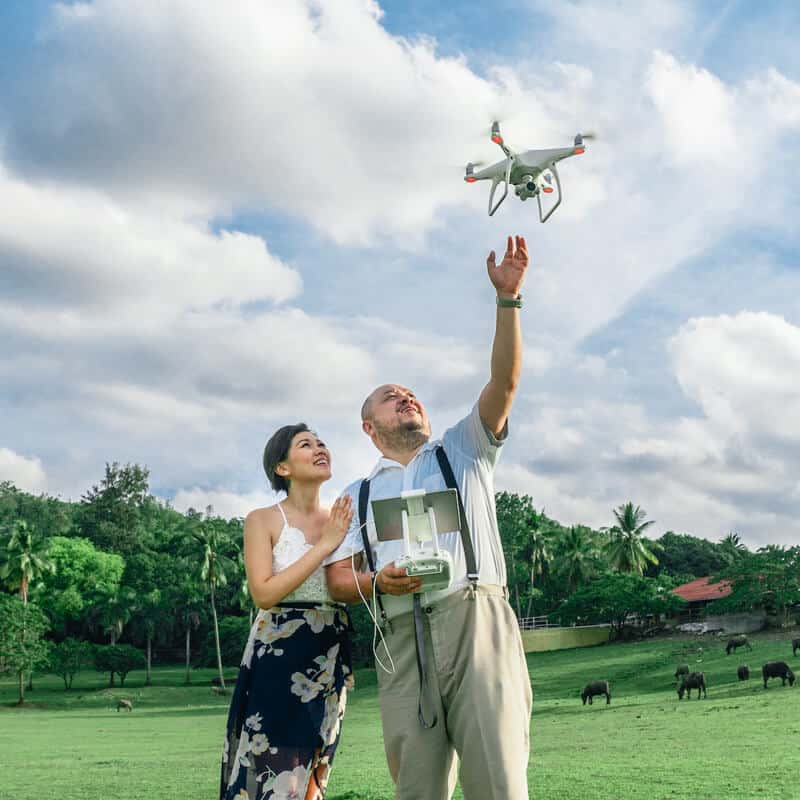 A man and a woman flying a drone